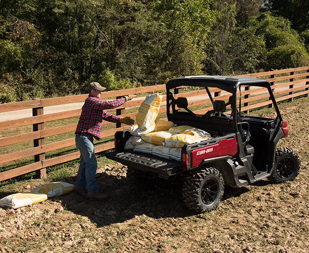hauling bags along fenceline in UTV